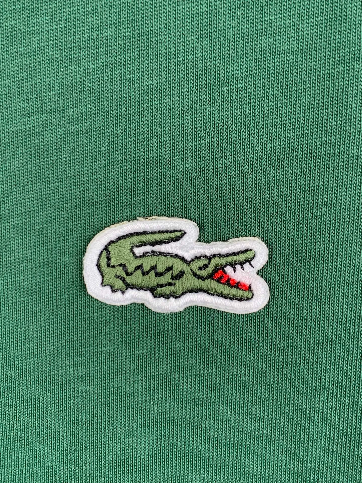 Lacoste crocodile logo short-sleeved T-shirt. Customized combed smooth plain cotton. Smooth and soft. Comfortable. Breathable. The pine dark green that has been deposited by time. The soft tones make people calm and calm. The iconic small crocodile pops up in the heart. The vivid logo contrasts with the calm background. The calm colors show the French style. Cut out the complexity and simplify it. Use solid color as the base and the logo as the print to show the texture and brand heritage in a low-key manner. Process 1: Use the car seal process. Make independent embroidered chapters through computer embroidery, then position them and sew them to fix them on the clothes. They have a strong three-dimensional effect, are strong and washable, and have stable quality. Process 2: The fabrics have been fermented and washed. They have a better hand feel and are not easy to deform, not easy to shrink, not easy to fade, and maintain long-term beauty. Accessories: Customized 1:1 Lacoste crocodile logo Customized 1:1 Lacoste trademark Version: Loose version Size: S M L XL